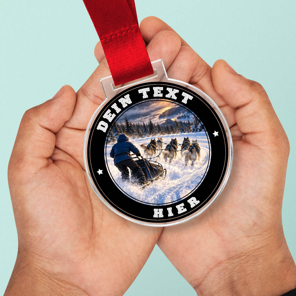 Signature Medaille Hundeschlitten in Händen als Größenvergleich