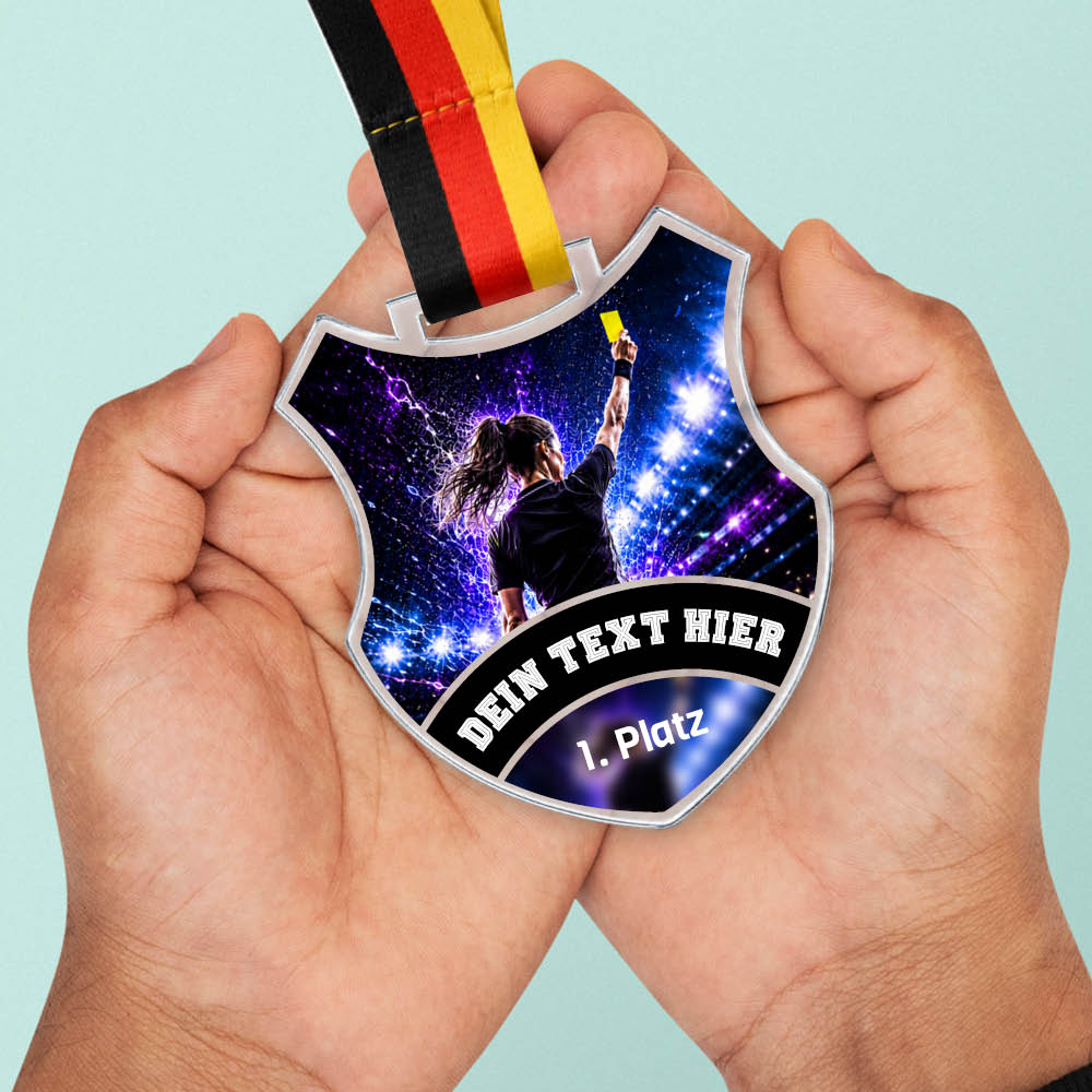 Wappen Medaille Beste Schiedsrichterin in Händen als Größenvergleich