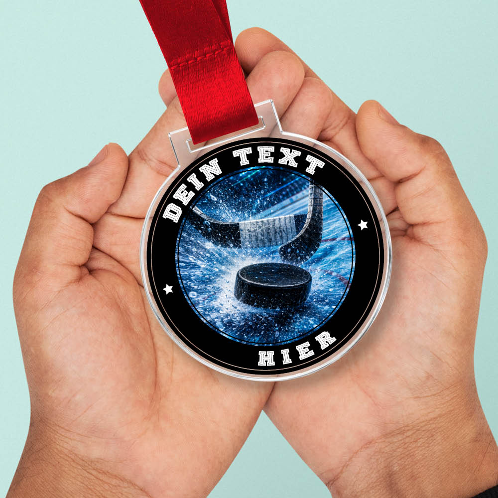 Signature Medaille mit Eishockeypuck und Schlägern in Händen als Größenvergleich